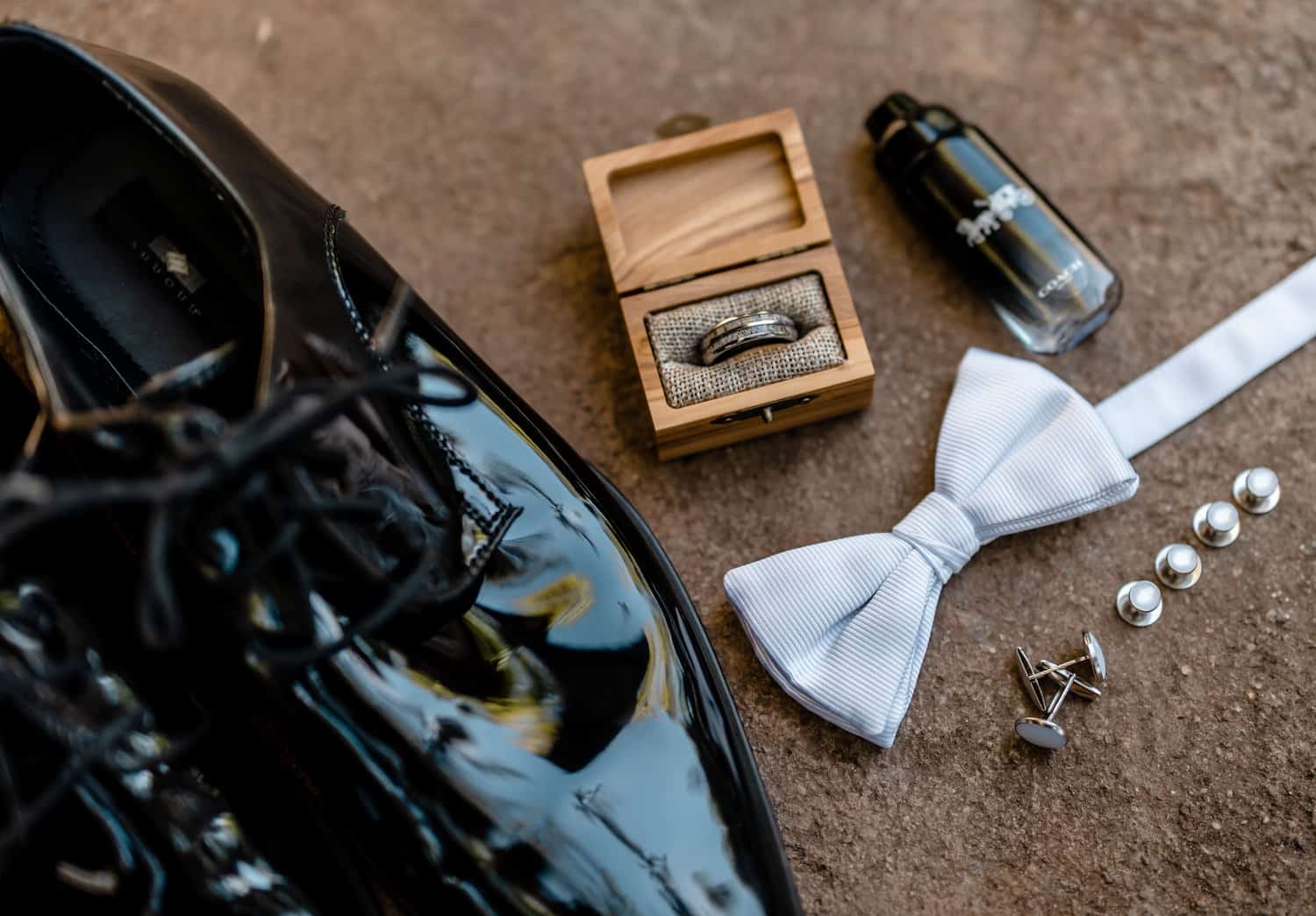 A pair of black shoes, a bowtie and a box of pearls.