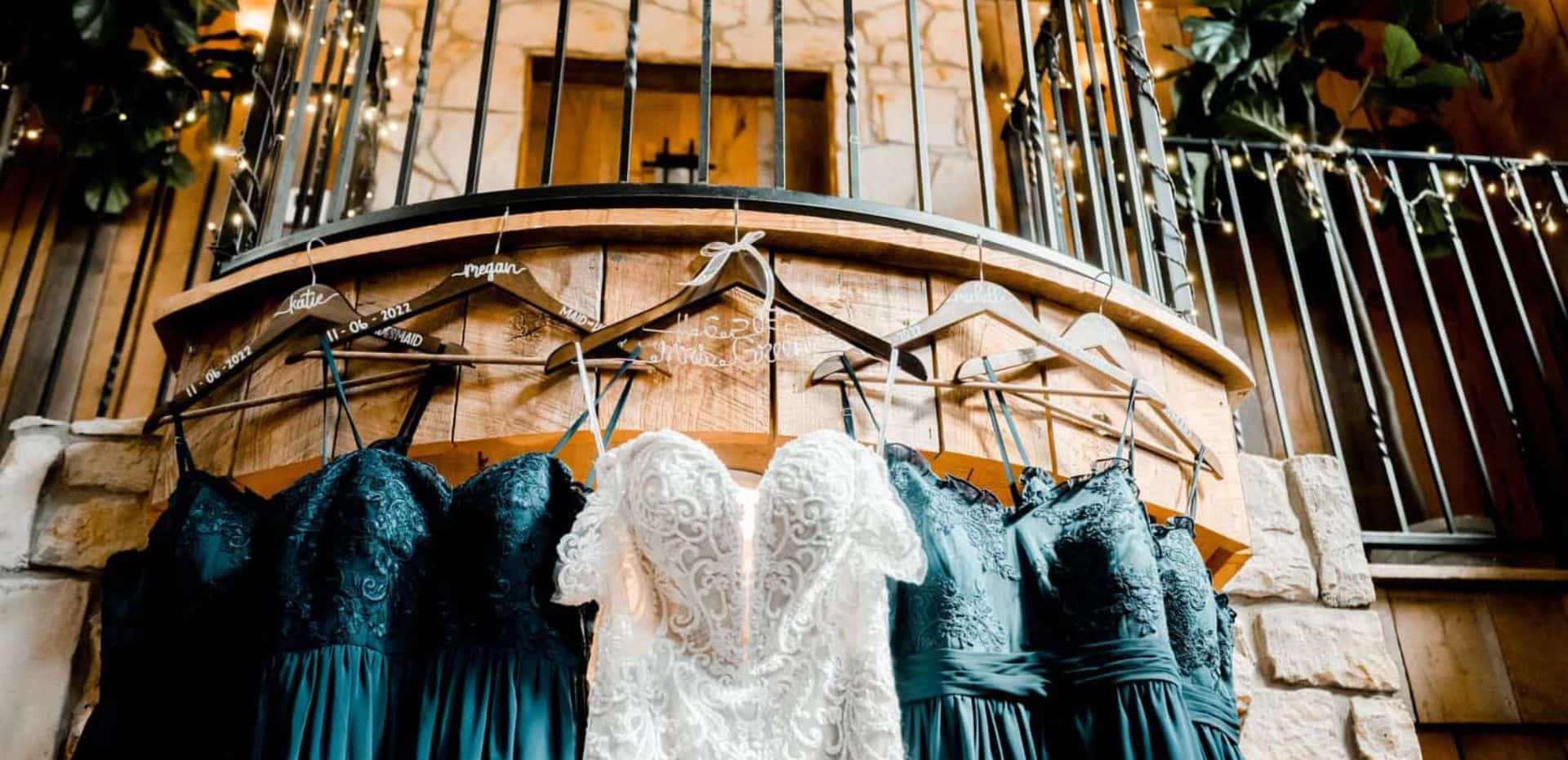 A wedding dress hangs on a railing in front of a staircase.