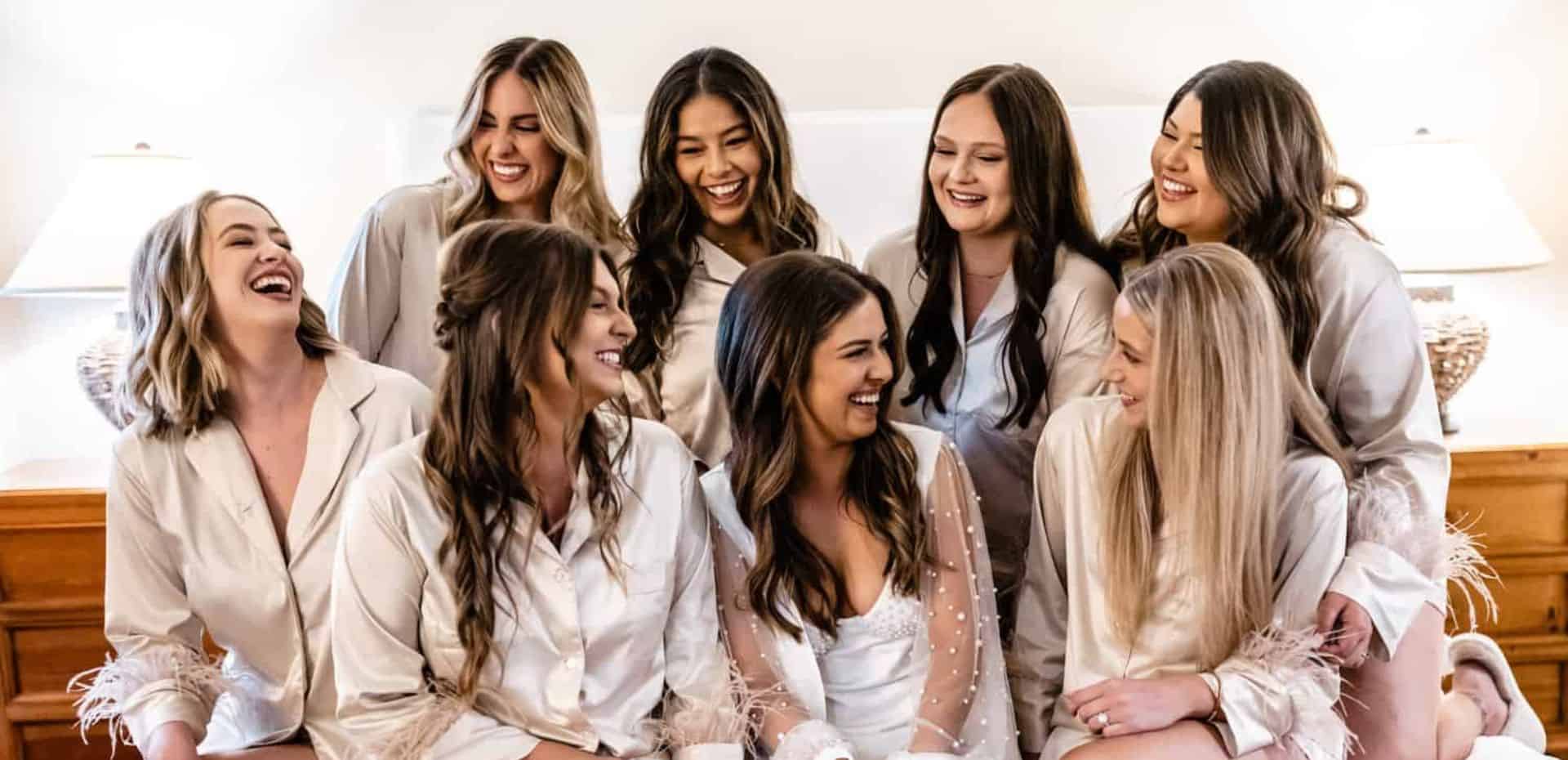 A group of bridesmaids laughing in their robes.